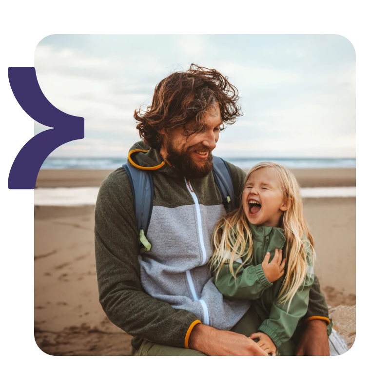 A father and young child enjoying the beach together, showing a return to normal life after a personal injury recovery.
